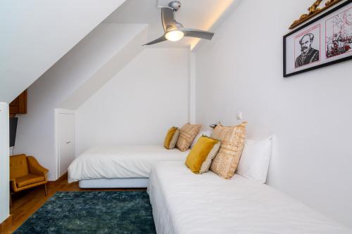 a bedroom with two beds and a ceiling fan at The Explorers Home - Sunny Stylish Family-Friendly Apartment in Lisbon