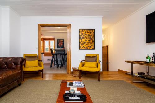 a living room with yellow chairs and a couch at The Explorers Home - Sunny Stylish Family-Friendly Apartment in Lisbon