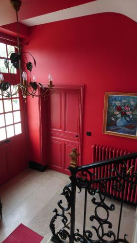 a room with red walls and a bed in it at Manoir de Conjon in Crouay