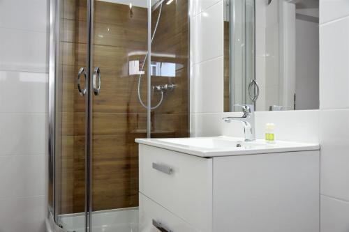 uma casa de banho com um lavatório e um chuveiro em Hostel Coco em Varsóvia