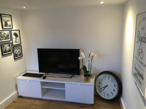 a white desk with a monitor and a clock at Château Martin in Esneux