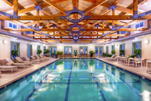 a pool with chairs and tables in a large building at The Equinox Golf Resort & Spa in Manchester