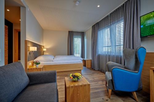 Habitación de hotel con cama y TV en Landgasthof Wurm, en Bogen