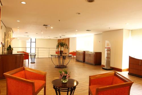 a lobby with two orange chairs and a table at Travel Inn Hotels Ibirapuera in Sao Paulo