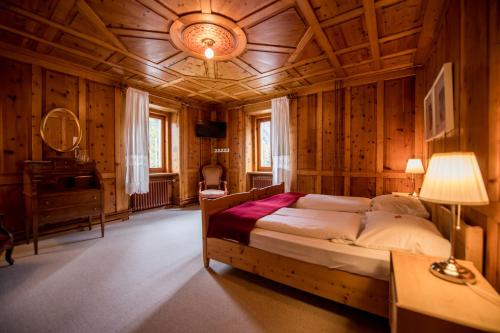Hotel Veduta في Cinuos-Chel: غرفة نوم بسرير وسقف خشبي