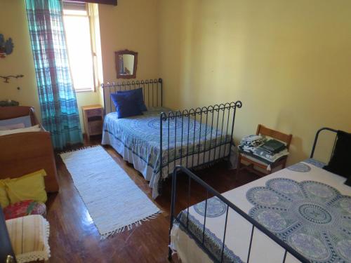 a living room with two beds and a living room with a bed at Casa São João in São João da Serra