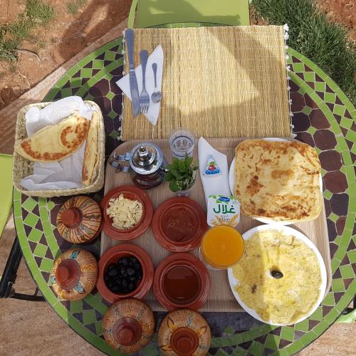 a table with food on it with a plate of food at Maison d'hôtes Tinwitchi in Azilal