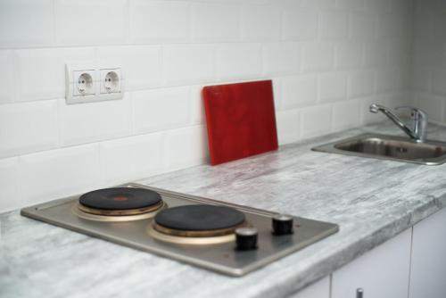 a kitchen counter with a sink and a stove with four pancakes at Deluxe Apartment in old city center in Lviv