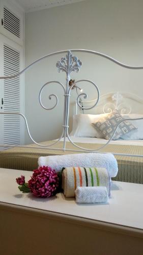 Porto FormosoにあるGreen House - ALのベッドにタオル2枚と花を用意したお部屋