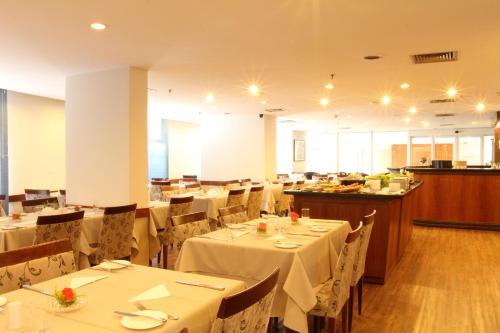 a dining room with tables and chairs with white table cloth at Travel Inn Hotels Ibirapuera in Sao Paulo