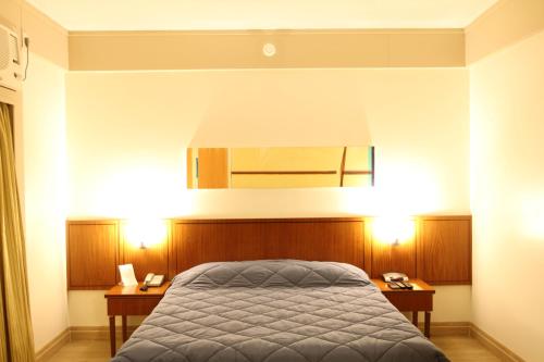 a bedroom with a bed and two night stands at Travel Inn Hotels Ibirapuera in Sao Paulo