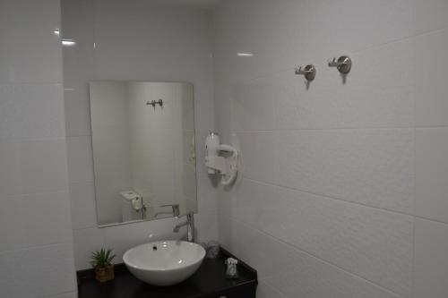 a white bathroom with a sink and a mirror at Hotel Español in La Pueblanueva