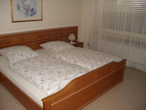 a bedroom with a bed with a wooden head board at Haus Muckenbruchblick -Ferienwohnung- in Erwitte