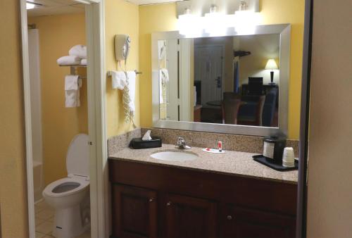 a bathroom with a sink and a toilet and a mirror at Baymont by Wyndham Sevierville Pigeon Forge in Sevierville