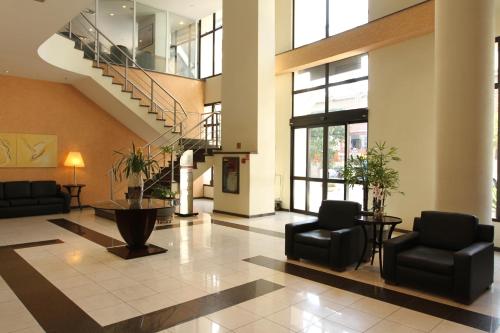 a lobby with chairs and stairs in a building at Travel Inn Hotels Ibirapuera in Sao Paulo