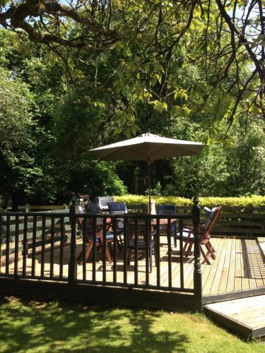a table with an umbrella and chairs on a deck at Sea Dew B&B in Tullamore
