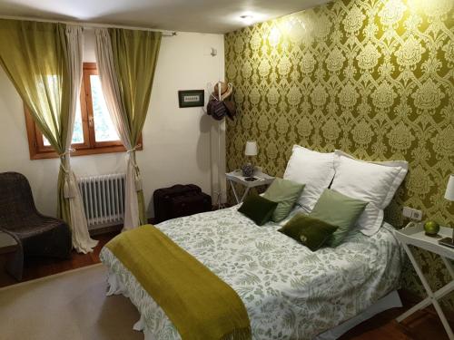 a bedroom with a bed with green and white sheets at Casa Marian Villanua in Villanúa