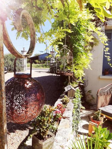 a garden with a large vase and some plants at La Marelle in Avrillé-les-Ponceaux