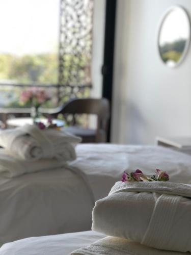 a white bed with white pillows and flowers on it at T Design Hotel Boutique in Tandil
