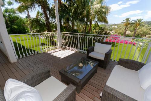 a patio with chairs and a coffee table on a deck at Hotel Simius Playa in Villasimius