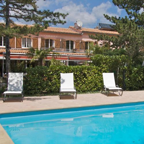 two chairs and a swimming pool in front of a house at lou pèbre d'aï in Plan dʼAups