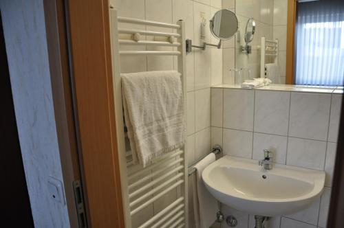 a white bathroom with a sink and a mirror at Hotel Bürgerhof in Homburg