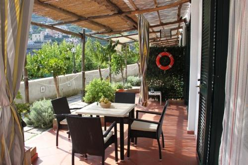 a patio with a table and chairs on a balcony at Eden Holiday in Minori