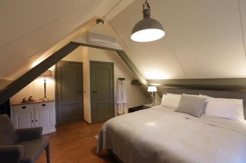 a bedroom with a large white bed in a attic at Lindenhof in Garderen