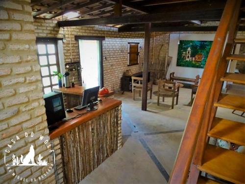 - un salon avec un mur en briques et une cheminée dans l'établissement Pousada Casa do Wolf, à São Miguel do Gostoso