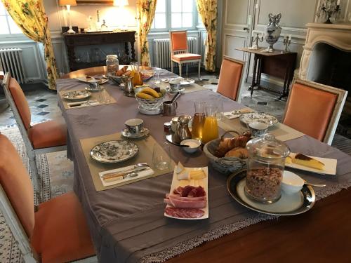 a table set with breakfast food on it at Le Château d'Asnières en Bessin in Asnières-en-Bessin