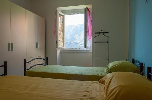 two beds in a room with a window at Bed &Breakfast Bellavista in San Giovanni Bianco