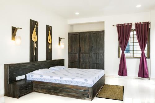 um quarto com uma cama num quarto com cortinas vermelhas em Green Roof - Family Room em Kolhapur