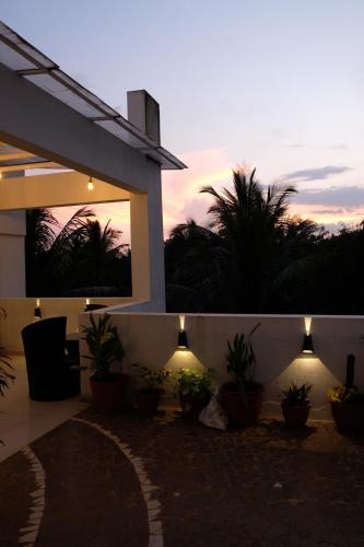 Una casa con macetas al costado. en Green Roof - Family Room, en Kolhapur