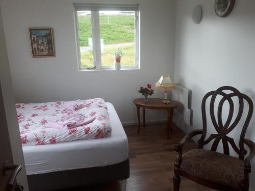 1 dormitorio con 1 cama, 1 silla y 1 ventana en Bikers Paradise, en Ólafsvík