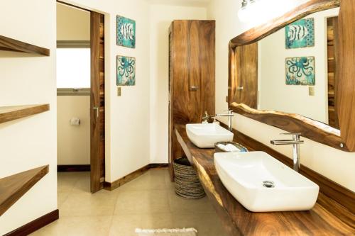a bathroom with two sinks and a mirror at Cocobolo Beach Boutique Hotel in San Juanillo