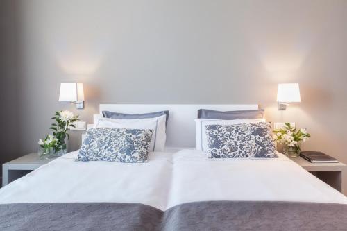 a bedroom with two beds with blue and white pillows at Hotel The Park Derio in Derio