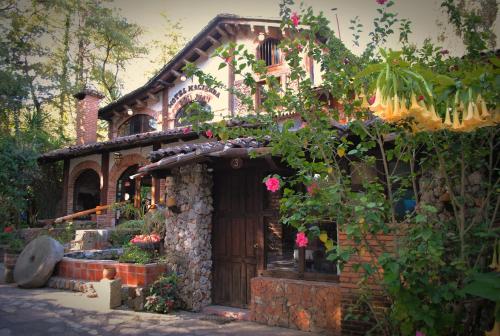 a house with a garden with flowers in front of it at Hotel Hacienda Don Juan in San Cristóbal de Las Casas