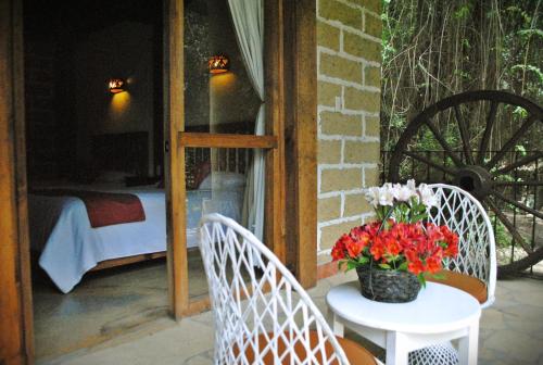 two chairs and a table with a vase of flowers at Hotel Hacienda Don Juan in San Cristóbal de Las Casas