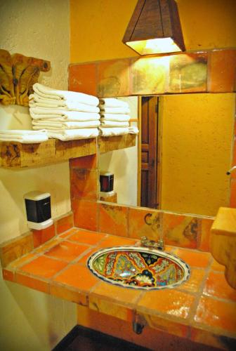 a bathroom counter with a sink and a mirror at Hotel Hacienda Don Juan in San Cristóbal de Las Casas