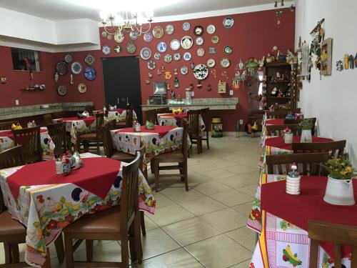 a restaurant with red walls and wooden tables and chairs at Hotel Vila Rica in Alfenas