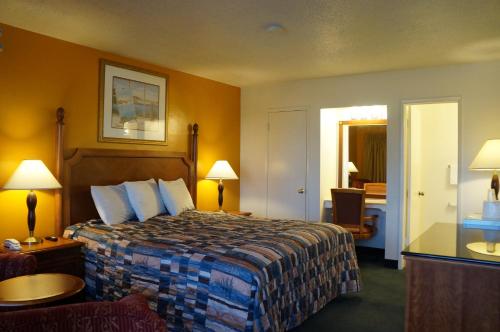 a hotel room with a large bed and a window at Classic Inn in Red Bluff