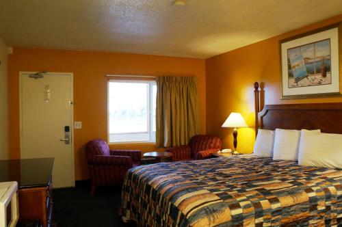 a hotel room with a bed and a window at Classic Inn in Red Bluff