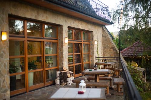 a patio with tables and chairs on a building at Podzamcze in Rożnów