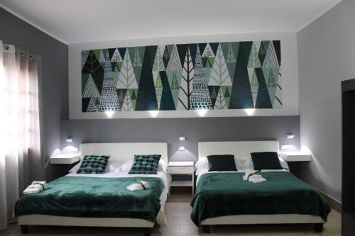 una camera con due letti e un dipinto sul muro di MAISON MARIANNA B&B - ETNA - a Nicolosi