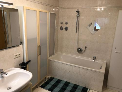 a bathroom with a shower and a tub and a sink at Ferienwohnung Aretsried in Fischach