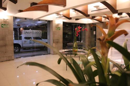 a vase of flowers on a table in front of a store at Hotel Colonial Hermosillo in Hermosillo