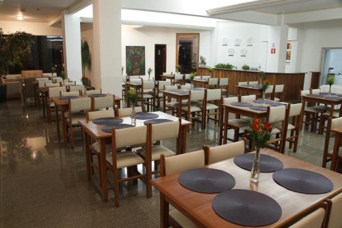 un restaurante con mesas de madera y sillas en una habitación en Hotel Kehdi Plaza, en Barretos
