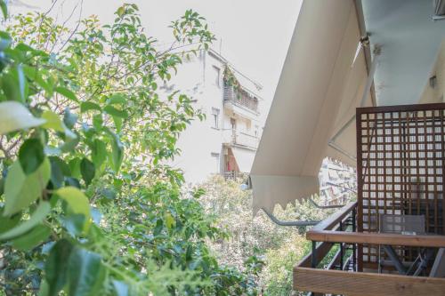 a balcony with trees and a building in the background at Chic and Minimal apartment close to Thissio Metro in Athens