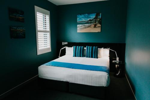 una camera con letto e parete blu di Junction Hotel a Newcastle