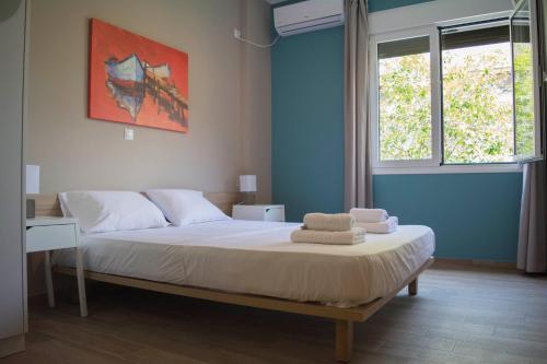 um quarto com uma cama, uma secretária e 2 janelas em Chic and Minimal apartment close to Thissio Metro em Atenas